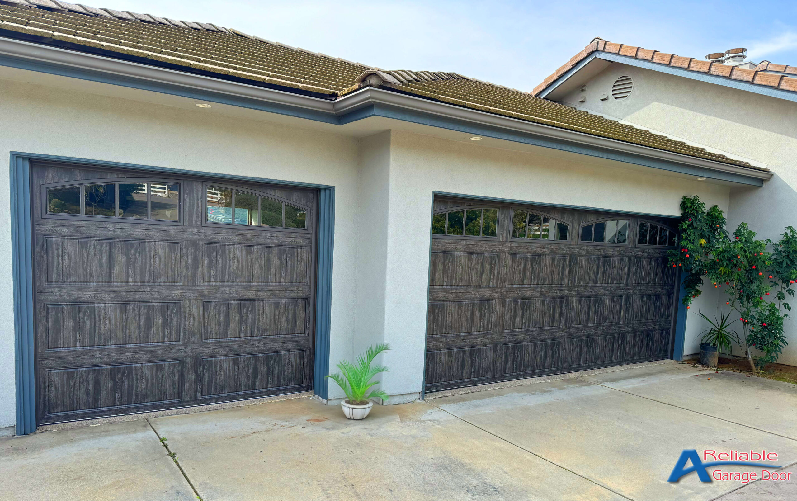 San Diego home with Clopay slate finish garage doors, demonstrating robust design and style, on a clear day.