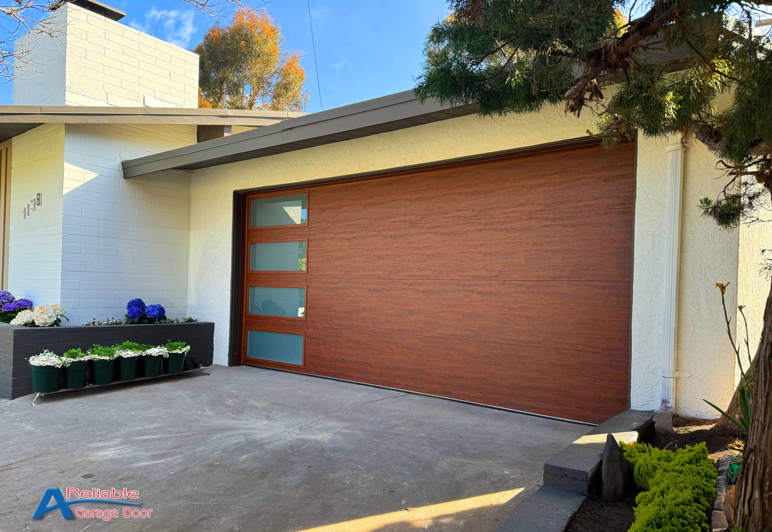 Chic Point Loma home featuring a Clopay modern steel flush garage door with a walnut finish, harmonizing with the coastal aesthetic.
