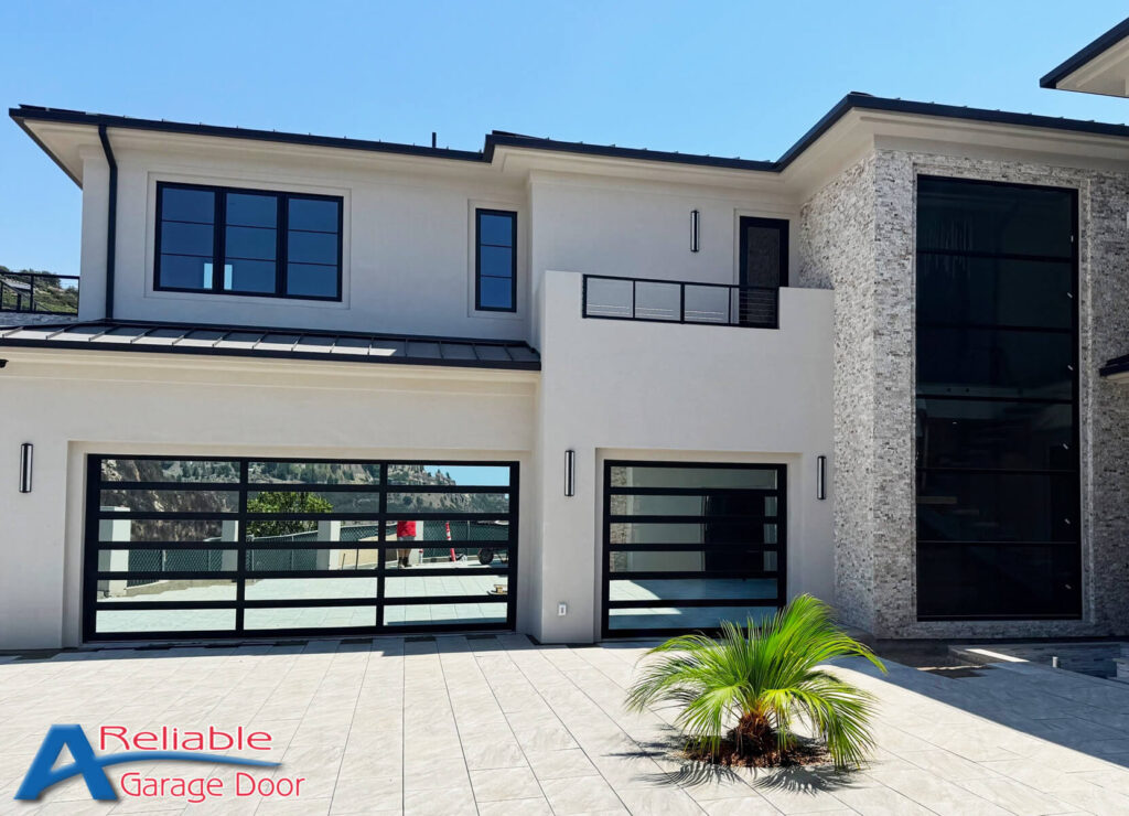 Sleek Clopay mirrored glass garage door reflecting the surroundings, installed by A Reliable Garage Door